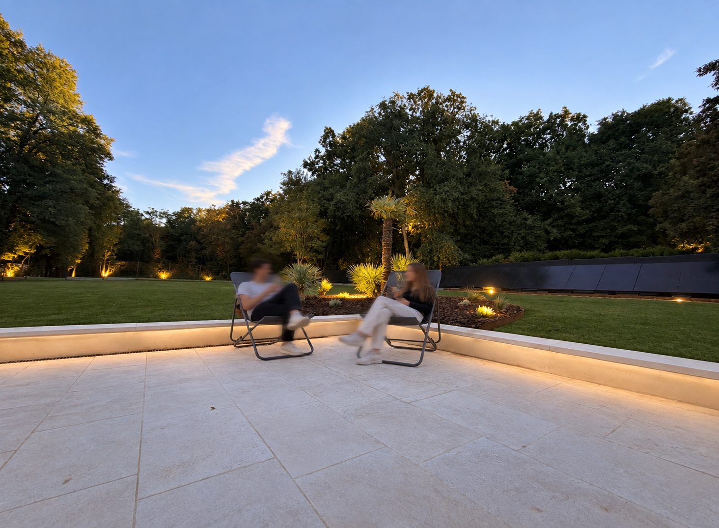Zwei Gäste genießen die Terrasse in der Abenddämmerung
